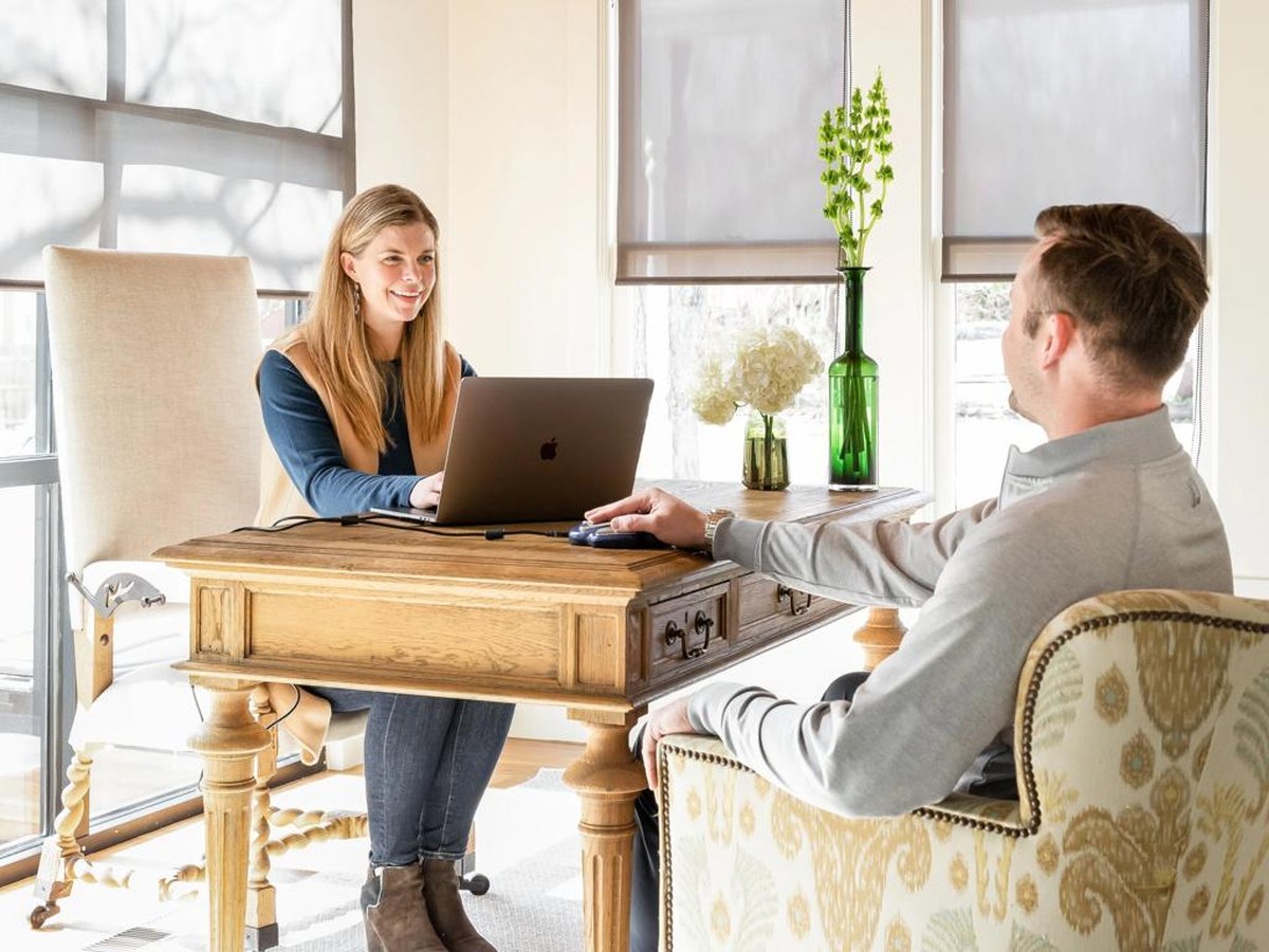 Consultant discussing healthcare resources with a client in a home office.